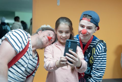 Ett barn som tar en selfie med två clowner